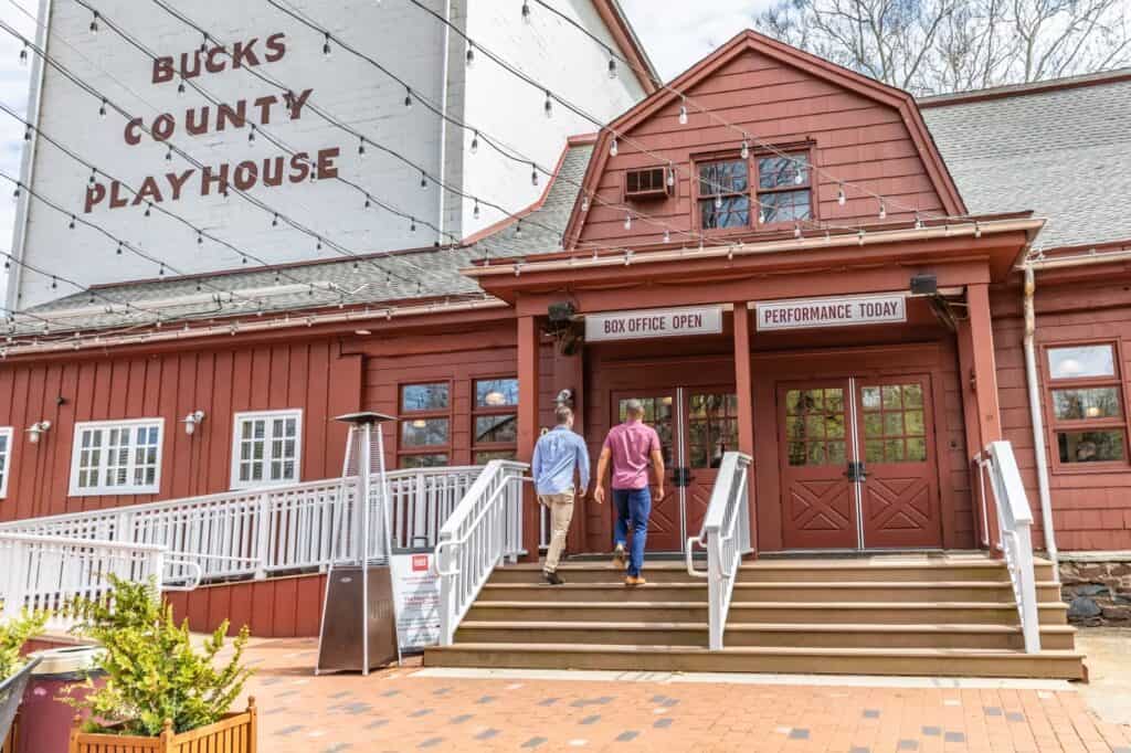 Two men walking up steps to Bucks County Playhouse in New Hope, PA, Bucks County - Excited theatergoers heading to iconic venue.