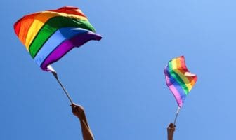 Waving rainbow flags in celebration of Pride.
