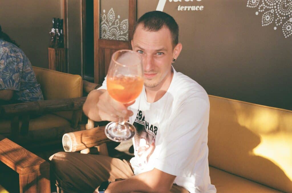 Traveler raising a glass of wine on a San Francisco wine country road trip, enjoying a relaxing stop at a local terrace.