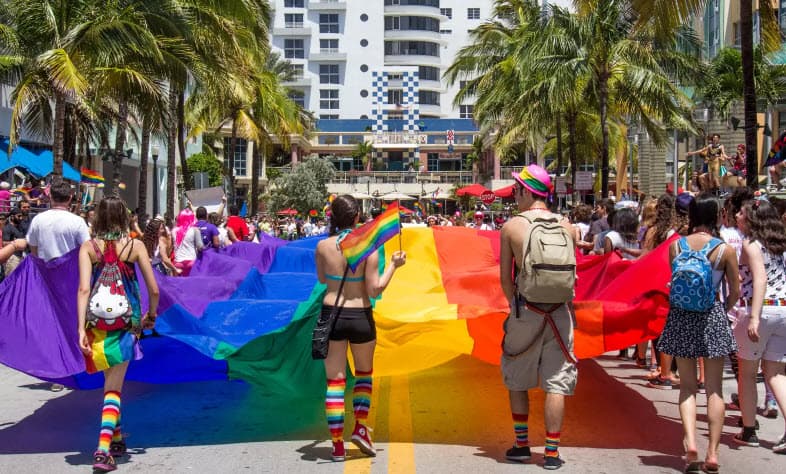 A vibrant procession fills Miami Beach streets with rainbow flags and cheering crowds during the annual Gay Pride Parade, celebrating love and equality during Rainbow Spring 2024.
