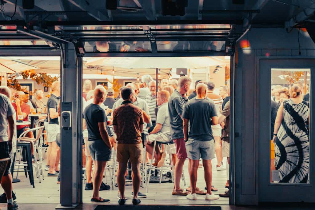 Gay men enjoying outdoor socializing at a bar in Rehoboth Beach, a vibrant LGBTQ+ friendly destination for nightlife and community.