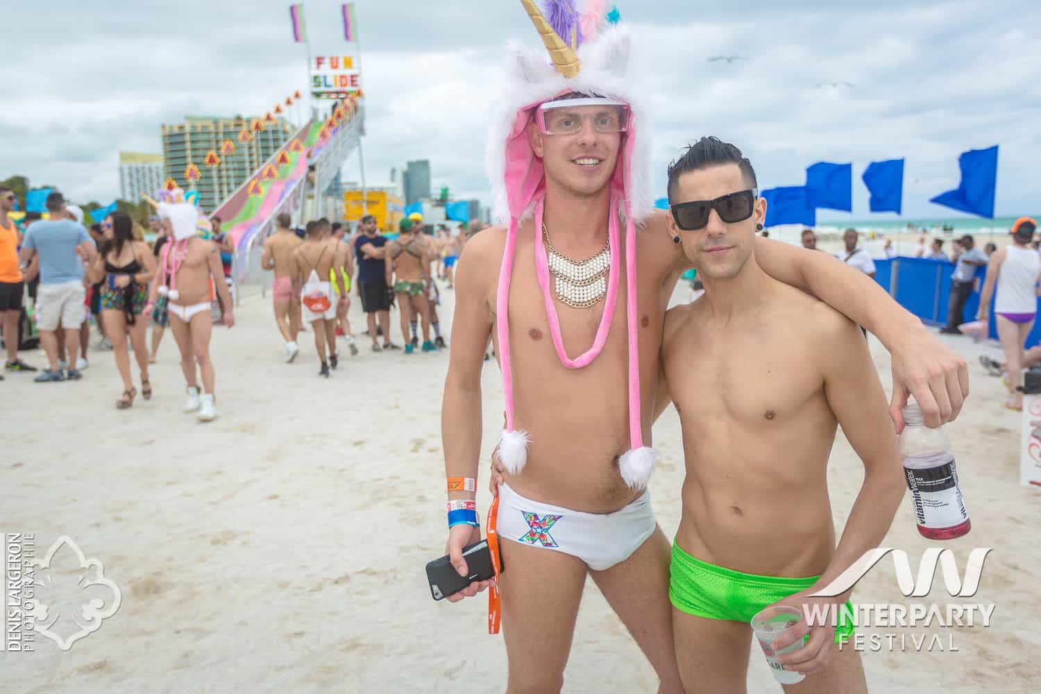 Two men embracing on the beach during the Miami Winter Party Festival, symbolizing love and unity amidst the celebration of diversity.