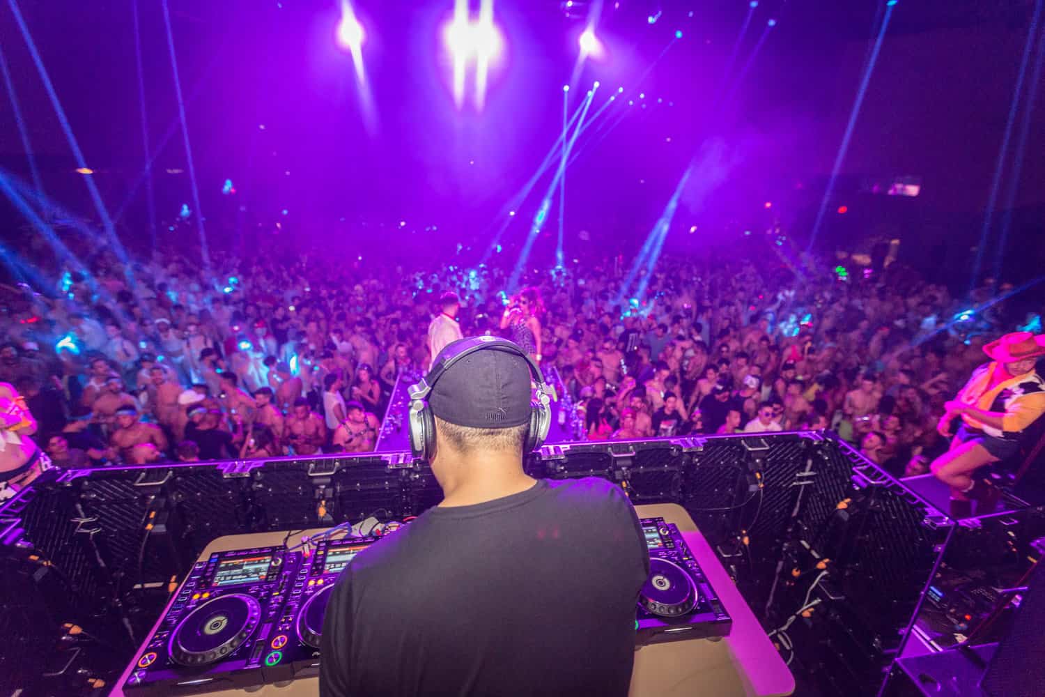 DJ spinning a set in his booth at the Miami Winter Party Festival, igniting the dance floor with electrifying beats and energy.