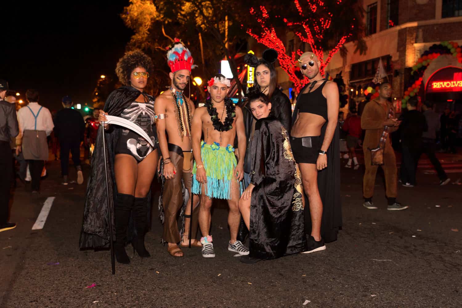 A lively street scene with a bunch of people wearing costumes for the West Hollywood Halloween Carnaval, a top LGBTQ+ Halloween event