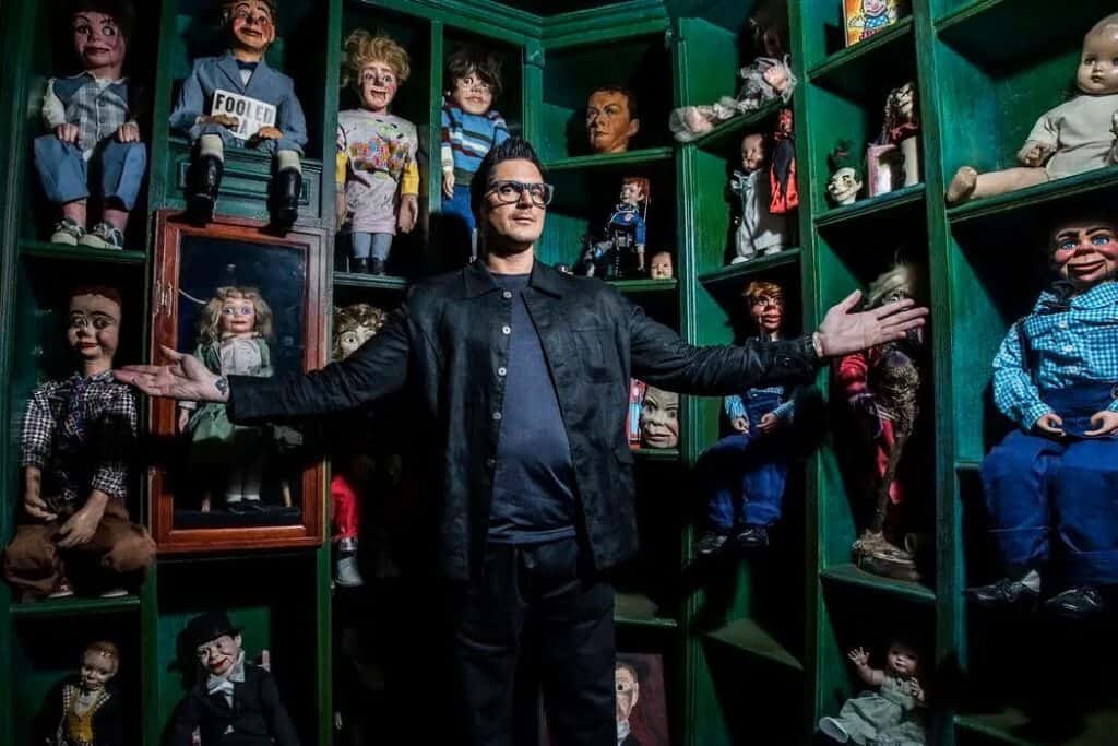 Zak Bagans standing in front of creepy dolls at the Haunted Museum in Las Vegas
