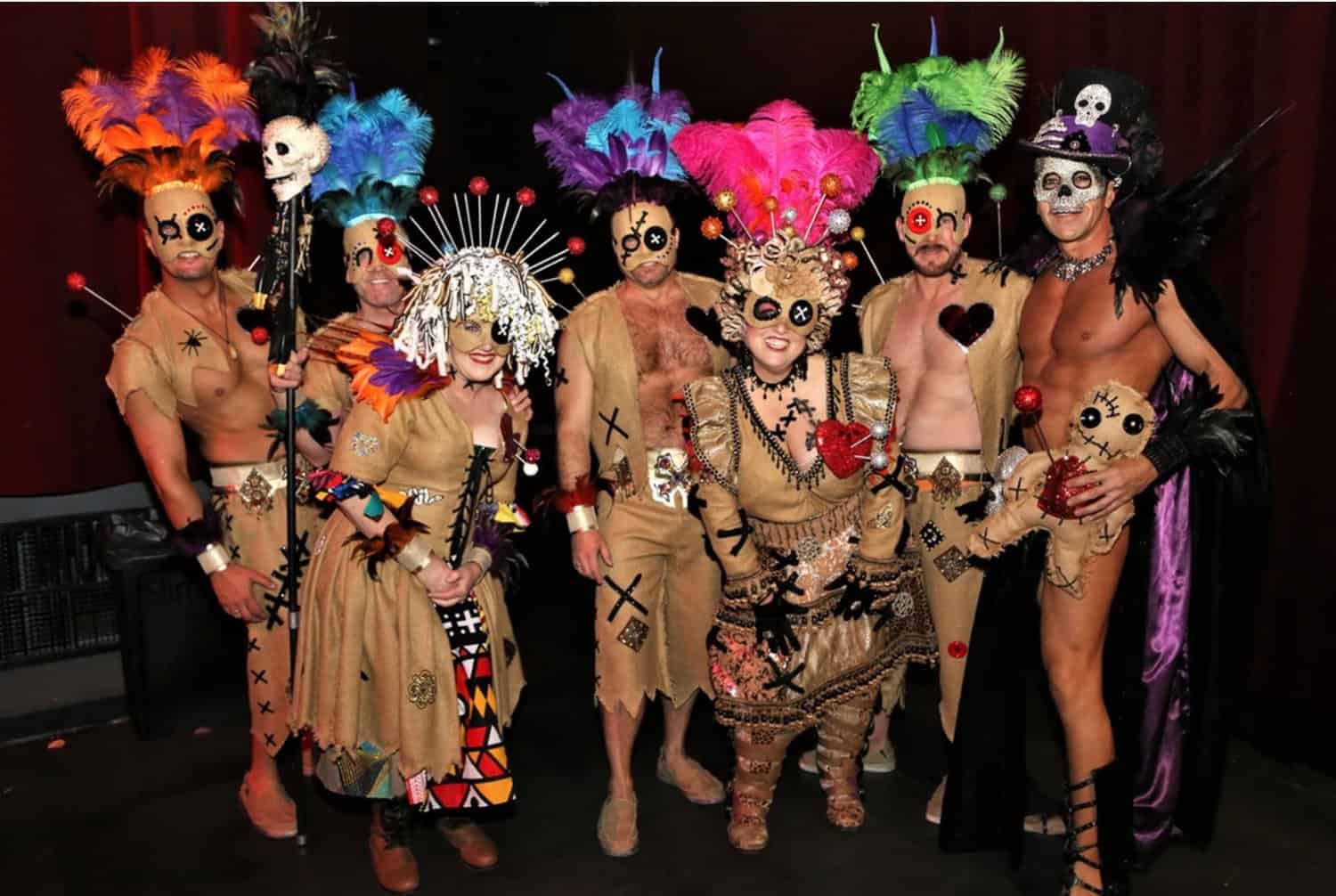 A cheerful bunch of friends in colorful costumes depicting voodoo dolls, ready to have a blast at Halloween New Orleans, a top LGBTQ+ event
