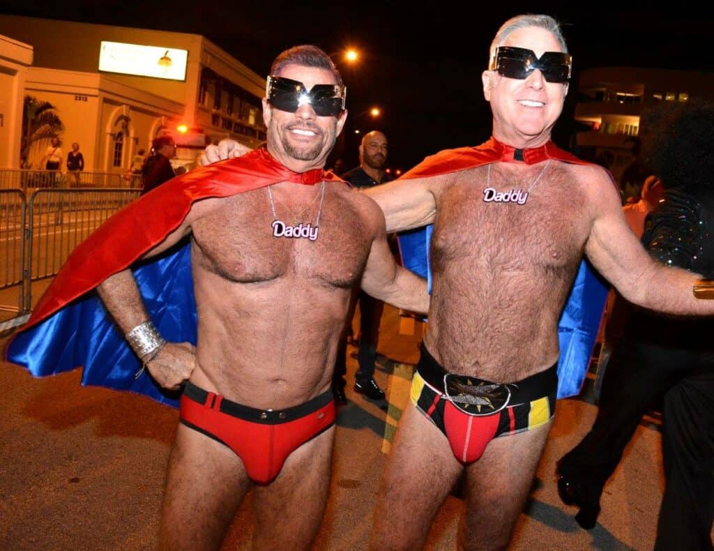 A dynamic daddy duo of superhero enthusiasts happily pose together for a photo at Wicked Manors, Fort Lauderdales top LGBTQ+ Halloween event