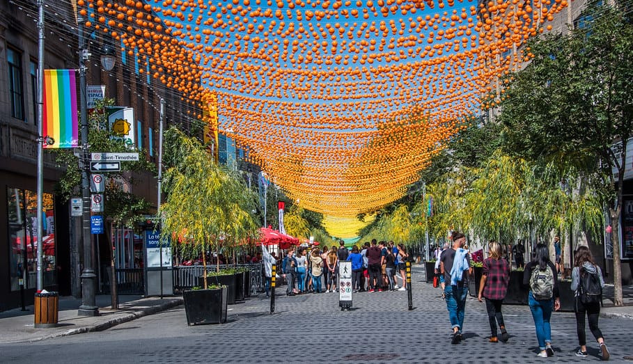 Colorful balls adorn St. Catherine Street, Montreal's vibrant Gay Village heart, creating a lively pedestrian mall scene from May to October.