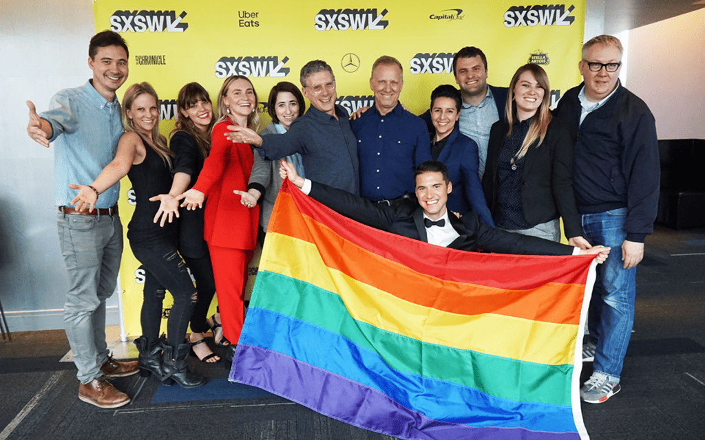 Vibrant group of LGBTQ+ individuals celebrating at a South by Southwest (SXSW) Pride event in Austin, Texas, showcasing inclusivity and community spirit.