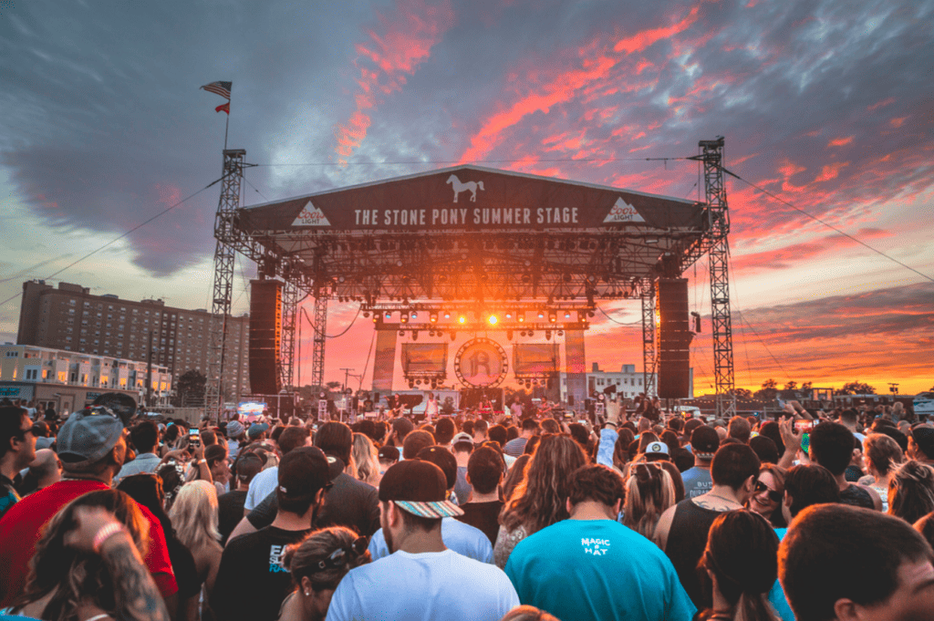 Concert-goers enjoying the Stone Pony summer concert series on Asbury Park beach, capturing the lively atmosphere of live music events.