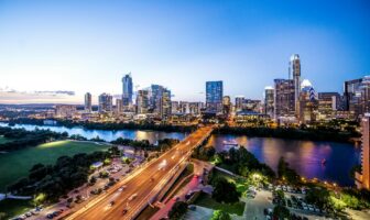 Cityscape of Austin, Texas skyline featuring prominent downtown buildings and vibrant city lights.