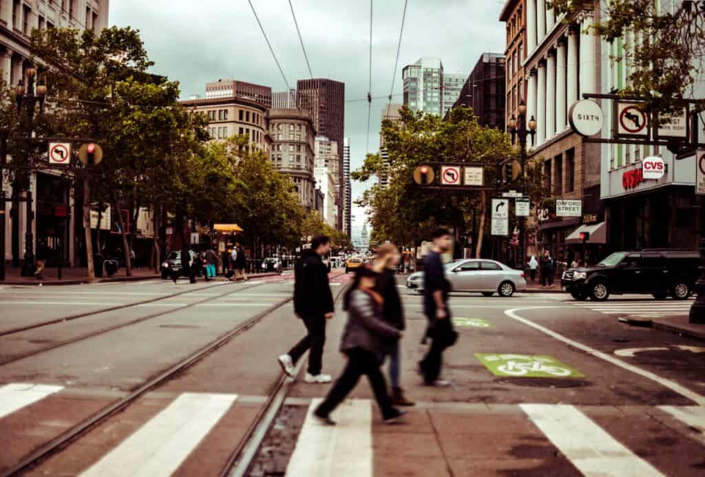 Pedestrians crossing street in San Francisco - Urban scene with people walking in crosswalk.