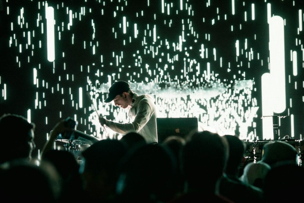 DJ performing at SXSW LGBTQ+ event in Austin, Texas, with vibrant lights illuminating the scene.