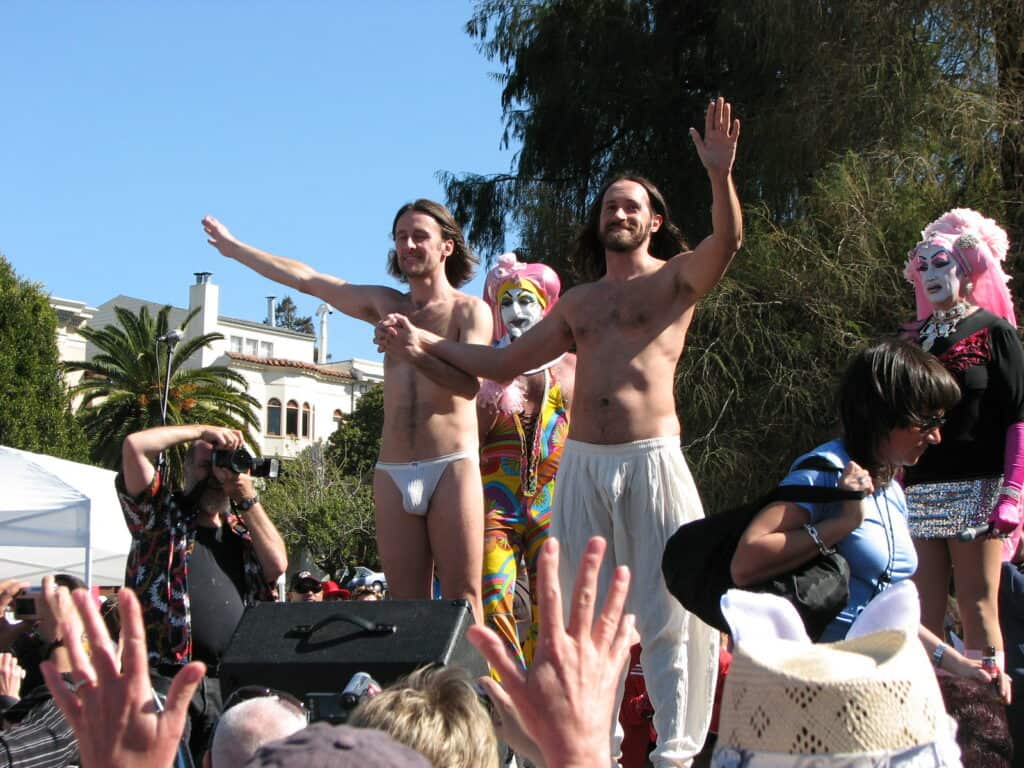 Two shirtless male contestants participate in the Hunky Jesus and Foxy Mary contest in San Francisco, a celebration of diversity and inclusivity in the LGBTQ+ community.