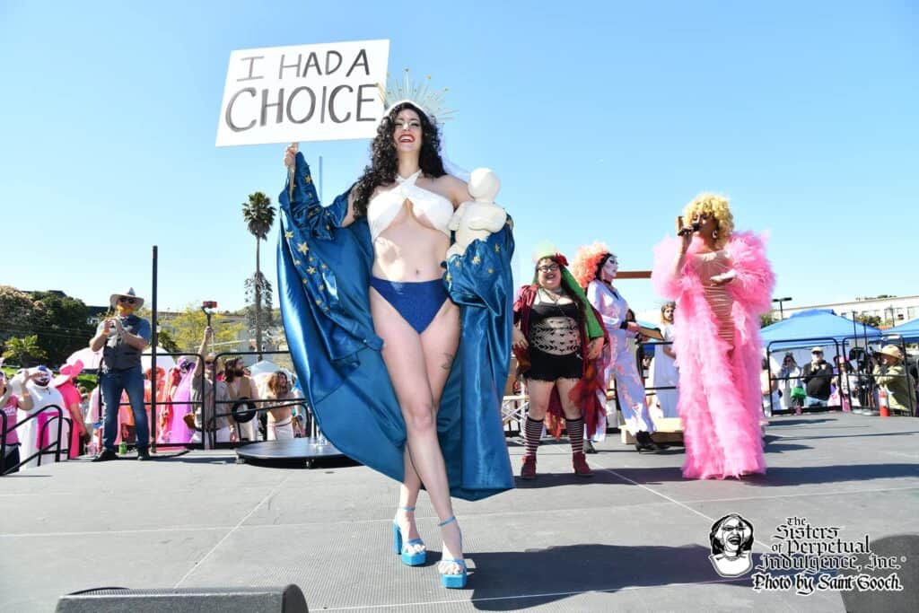 The winning Mary at the Hunky Jesus and Foxy Mary contest in San Francisco stands adorned in her costume, celebrating diversity and inclusivity in the LGBTQ+ community.