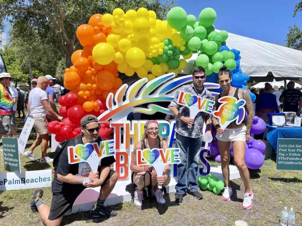 Group joyfully celebrating with colorful balloons at Palm Beach Pride, highlighting diversity and inclusion in spring LGBTQ+ pride events.