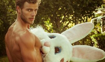 Shirtless man holding plush bunny rabbit head, a playful image representing LGBTQ+ Easter celebrations and gay-friendly getaways.