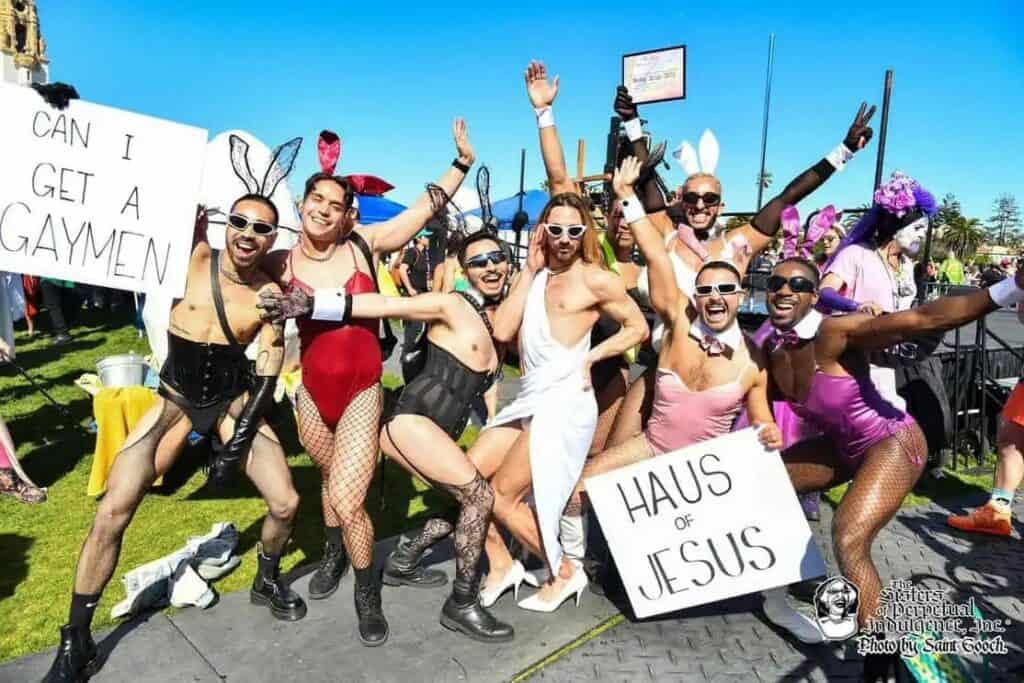 Group of men wearing bunny ears surrounding a 'Hunky Jesus' competitor at the Hunky Jesus contest in San Francisco, a lively representation of LGBTQ+ Easter celebrations.