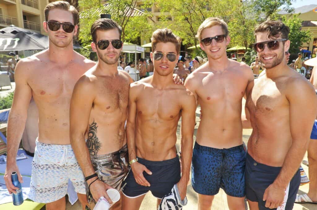Group of five shirtless men at White Party in Palm Springs, California, a renowned LGBTQ+ event.