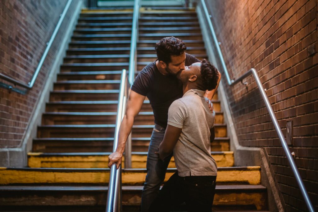 Two men kissing, representing love and inclusivity in LGBTQ travel.