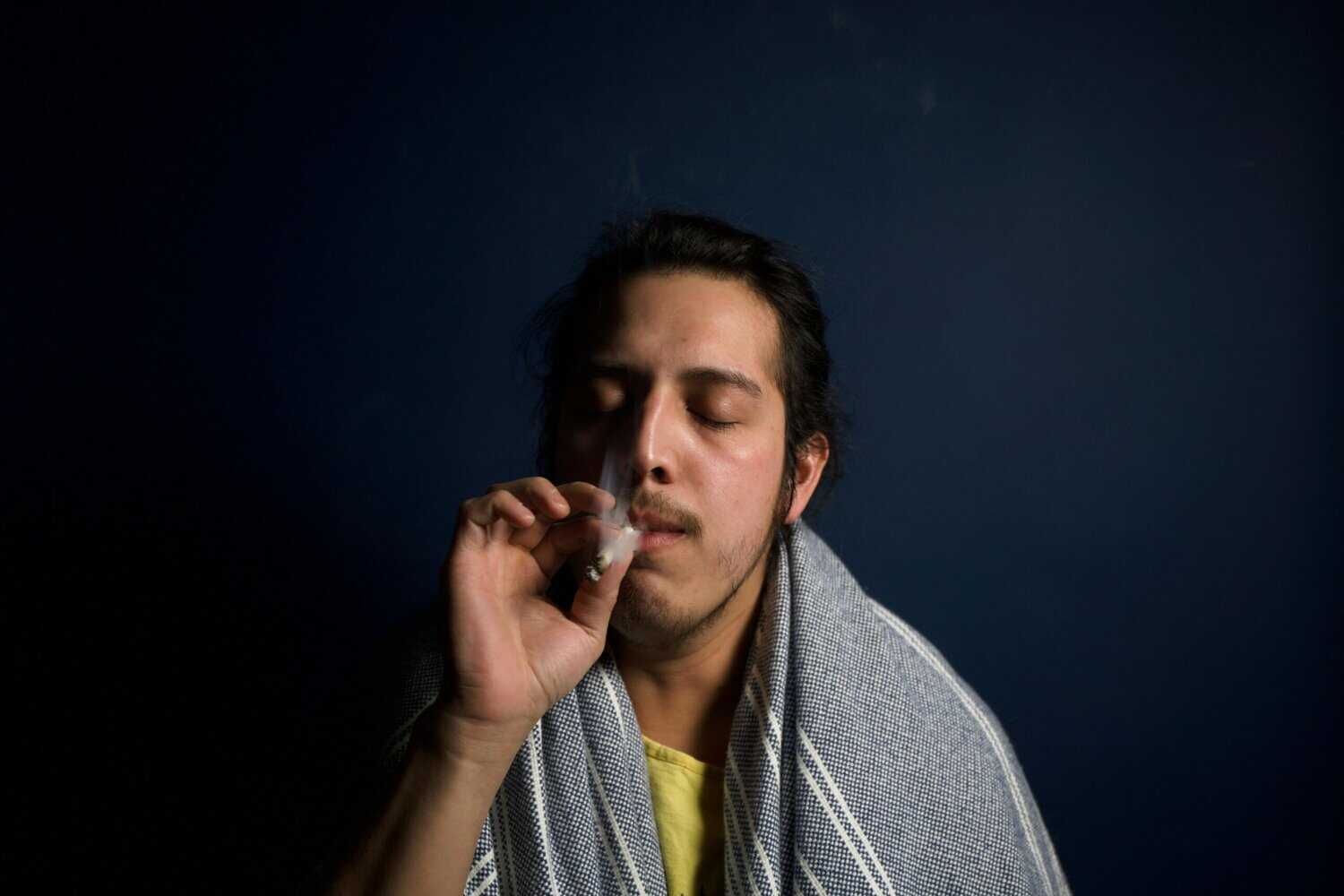 Man smoking a joint outdoors, representing cannabis use while traveling for a weed travel legality guide.