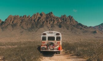 A converted school bus parked in a desert landscape, symbolizing the shift from van life to buslife.
