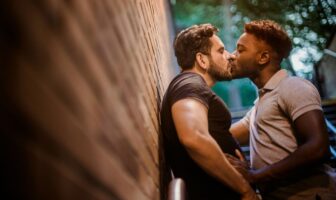 Two men kiss in a hidden alleyway, reflecting intimacy and connection in London top gay cruising culture.