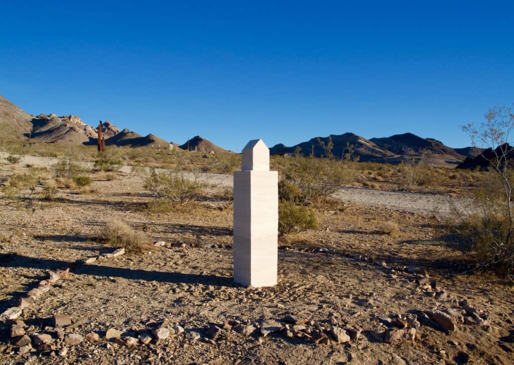 A solitary stone marker in Rhyolite, Nevada desert honoring the dream of a queer utopian community, part of Hidden LGBTQ+ History USA.