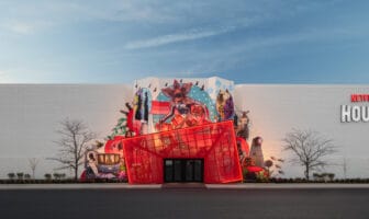Exterior of Netflix House King of Prussia featuring a bold red entrance and large mural of Netflix characters on the mall façade.