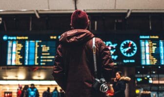A traveler checks the departure board for flight updates, a visual guide for Thanksgiving airport travel tips and planning.