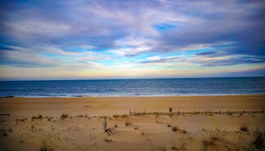 Scenic view of Rehoboth Beach coastline with golden sand and azure waters, a popular LGBTQ+ friendly destination for travelers.