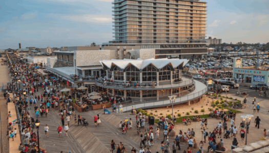 Busy Asbury Park boardwalk with Wonder Bar in the distance, showcasing vibrant atmosphere and iconic landmarks.